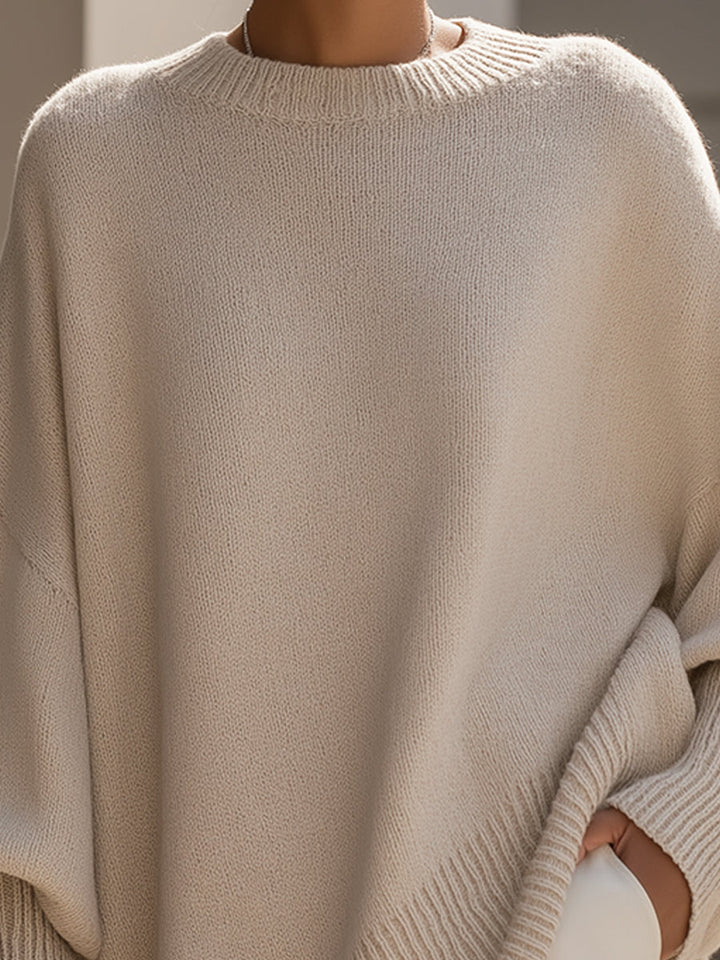 Nahaufnahme der feinen Strickstruktur und des gerippten Rundhalsausschnitts am beigen Poncho 3
