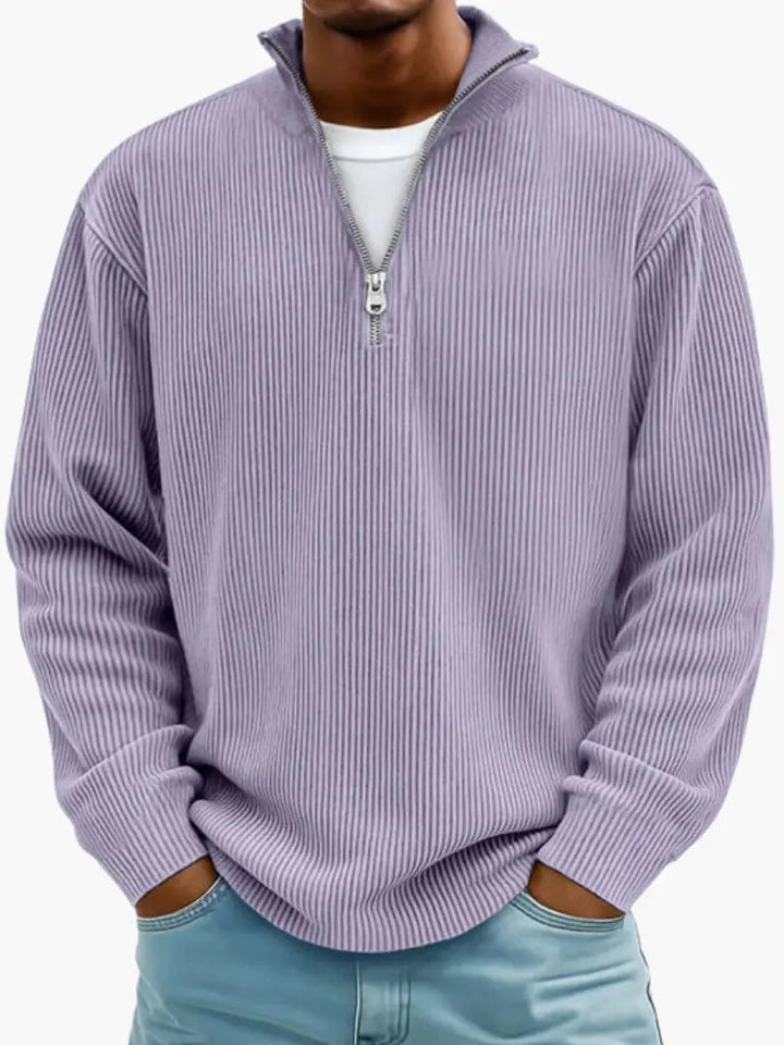 Frontansicht des gerippten Pullovers in Flieder mit Stehkragen und Viertelreißverschluss, getragen zu einer Jeans. 9
