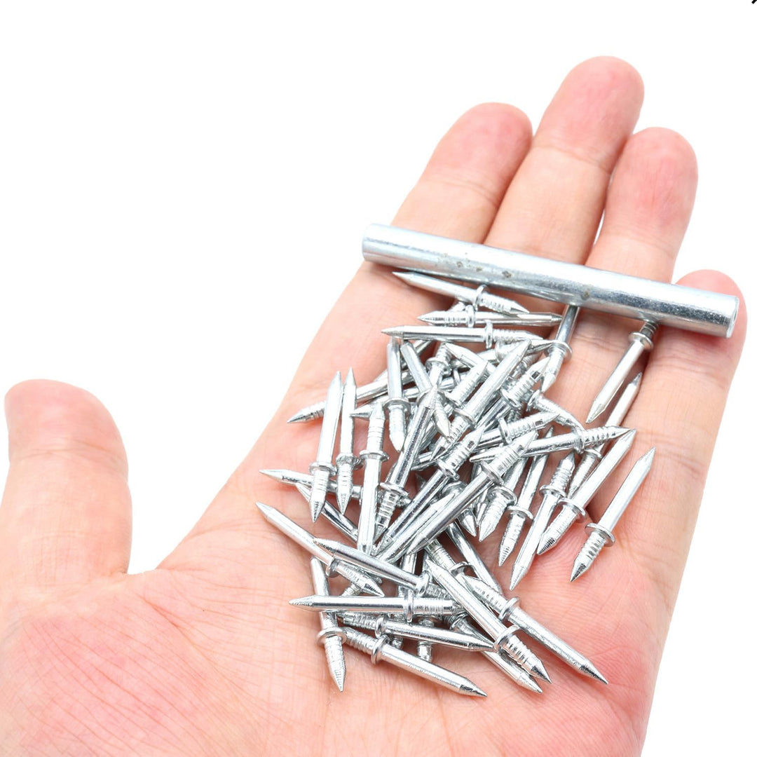 Eine Handfläche hält eine Handvoll doppelseitiger silberfarbener Metallnägel mit Rille und Bund neben dem zylindrischen Hülsenwerkzeug. 1