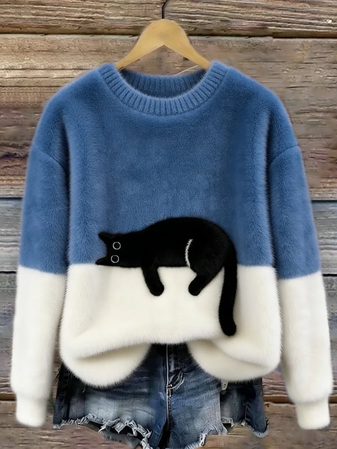 Blau-weißer Flauschpullover mit schwarzer Katze auf Kleiderbügel vor Holzwand, darunter Jeansshorts 9