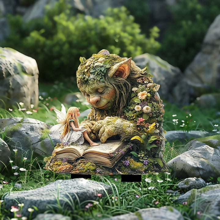 Moos-Troll mit Elfe und Buch zwischen Felsen und Gras, mit schwarzen Steckfüßen im Boden stehend. 12