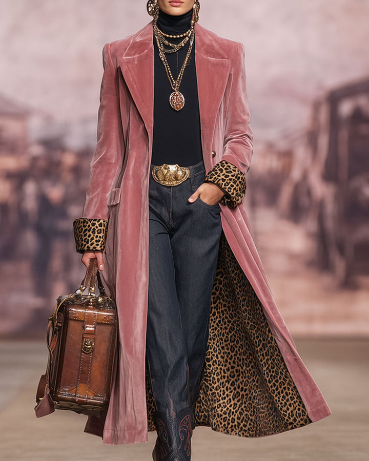 Model auf dem Laufsteg trägt den rosa Samtmantel offen, die Hand in der Jeanstasche, mit Lederkoffertasche und Goldketten. 3