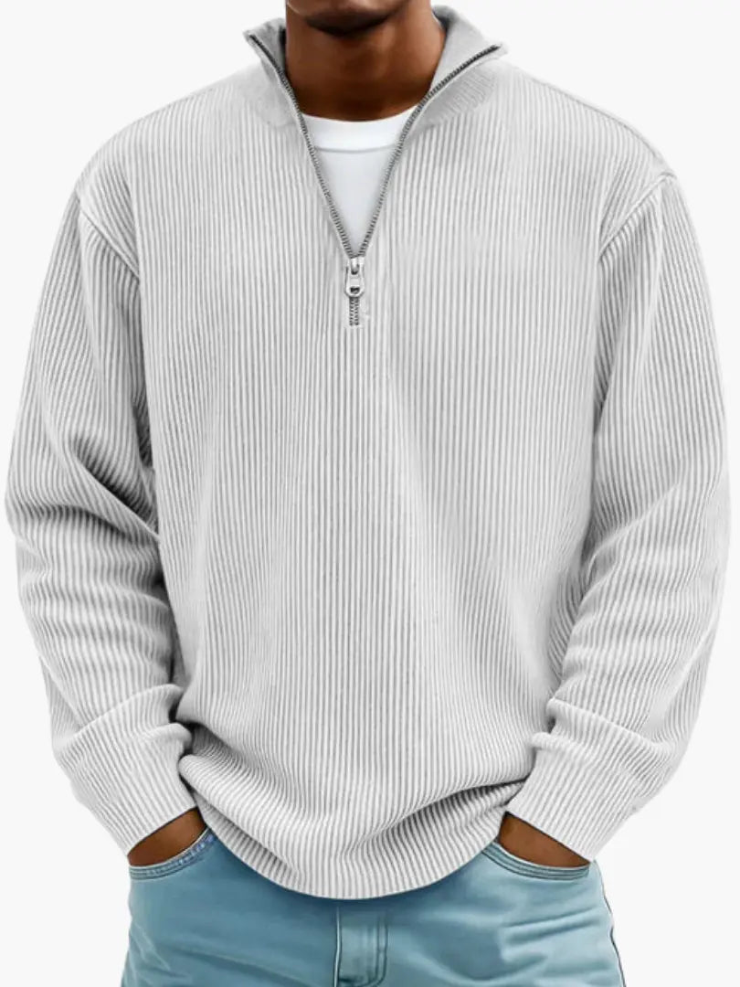 Frontansicht des gerippten Pullovers in sehr hellem Grau, getragen über weißem Shirt, mit lockerem Sitz und Stehkragen. 6