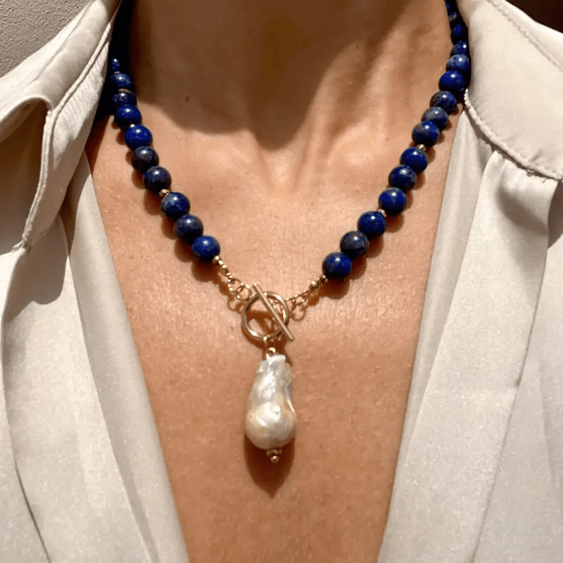 Kette mit blauen Perlen und Knebelverschluss, getragen an einer Frau in cremefarbener Bluse, Barockperle als Anhänger 1