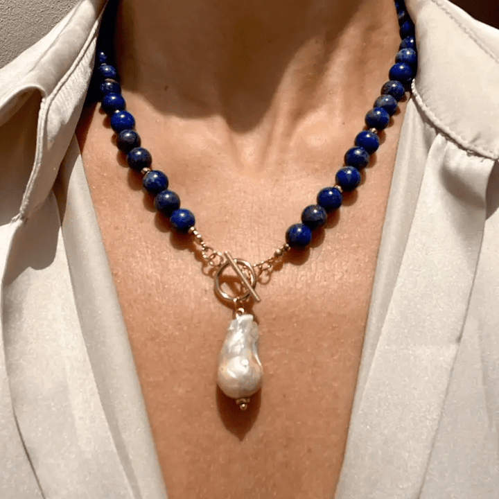Kette mit blauen Perlen und Knebelverschluss, getragen an einer Frau in cremefarbener Bluse, Barockperle als Anhänger 1
