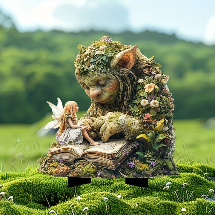 Schlafender Moos-Troll mit Blumen und Blättern liest in einem Buch, auf dem eine Elfe sitzt, auf einer Moosfläche. 2
