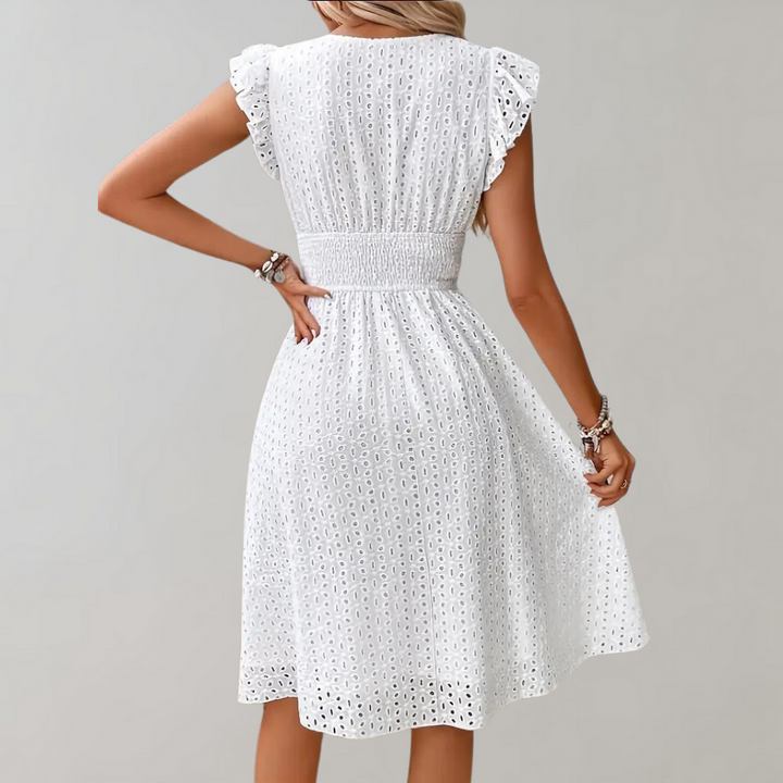 Frau in weißem Spitzenkleid mit Rüschenärmeln, Sommermode, elegantes Design, Rückansicht.
