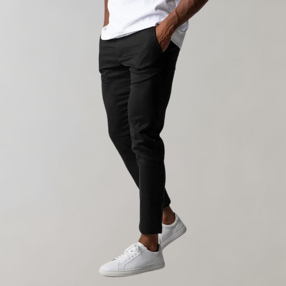 Mann trägt schwarze Chinohose und weiße Sneaker, lässiger Stil, Herrenmode.