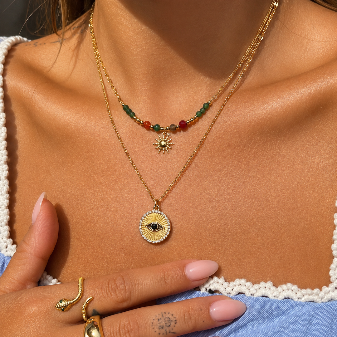 Frau trägt die Perlenkette mit Sonnenanhänger übereinander mit einer zweiten goldenen Kette mit rundem Anhänger 3