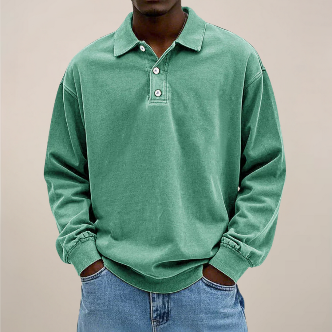 Das Langarm-Poloshirt in frischem Grün an einem Model, lockere Passform, Hände in den Jeanstaschen. 9