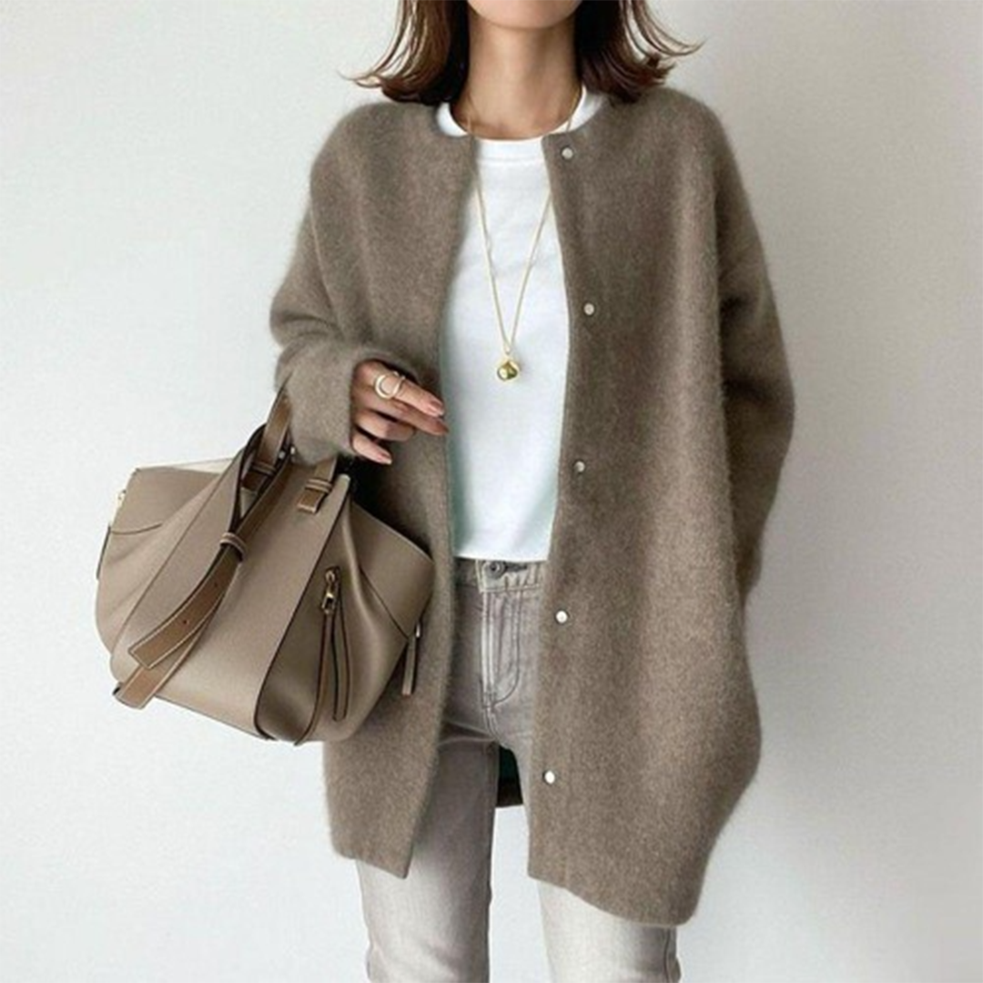 Frau trägt die flauschige Strickjacke in Taupe mit Druckknöpfen, weißem Shirt und heller Jeans 7