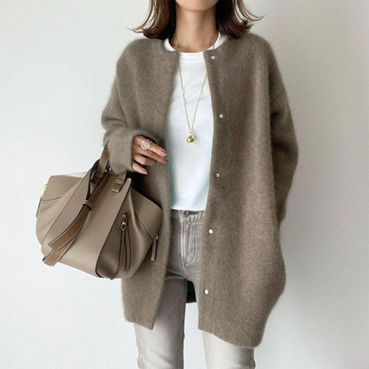 Frau trägt die flauschige Strickjacke in Taupe mit Druckknöpfen, weißem Shirt und heller Jeans 7