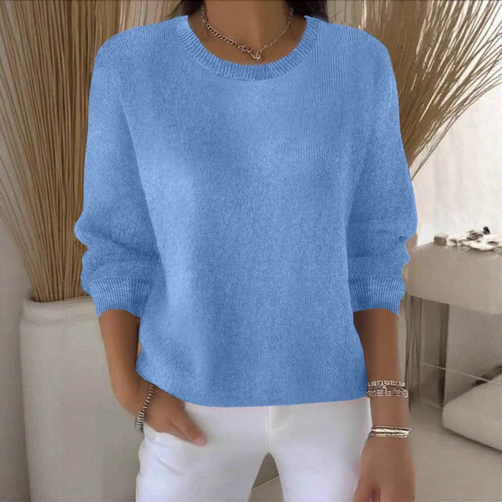 Hellblaue Variante des Strickpullovers am Model, getragen vor Pampasgras und heller Kommode 13