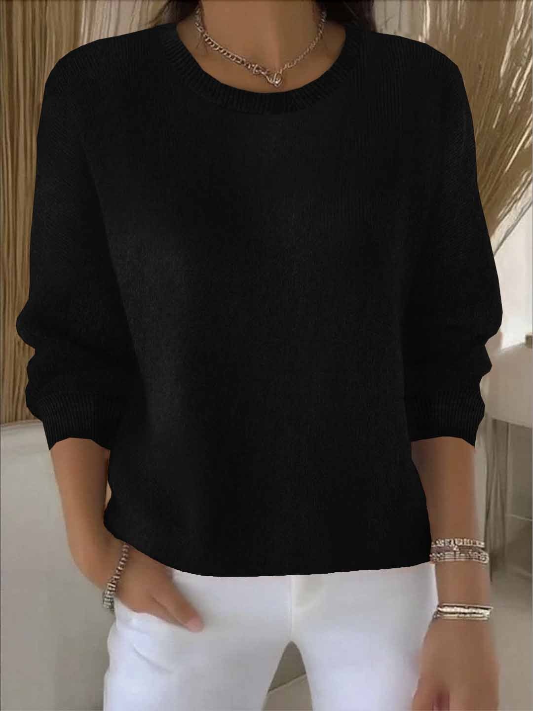 Schwarze Variante des Strickpullovers am Model, Rundhalsausschnitt, kombiniert mit weißer Hose und Silberschmuck 7
