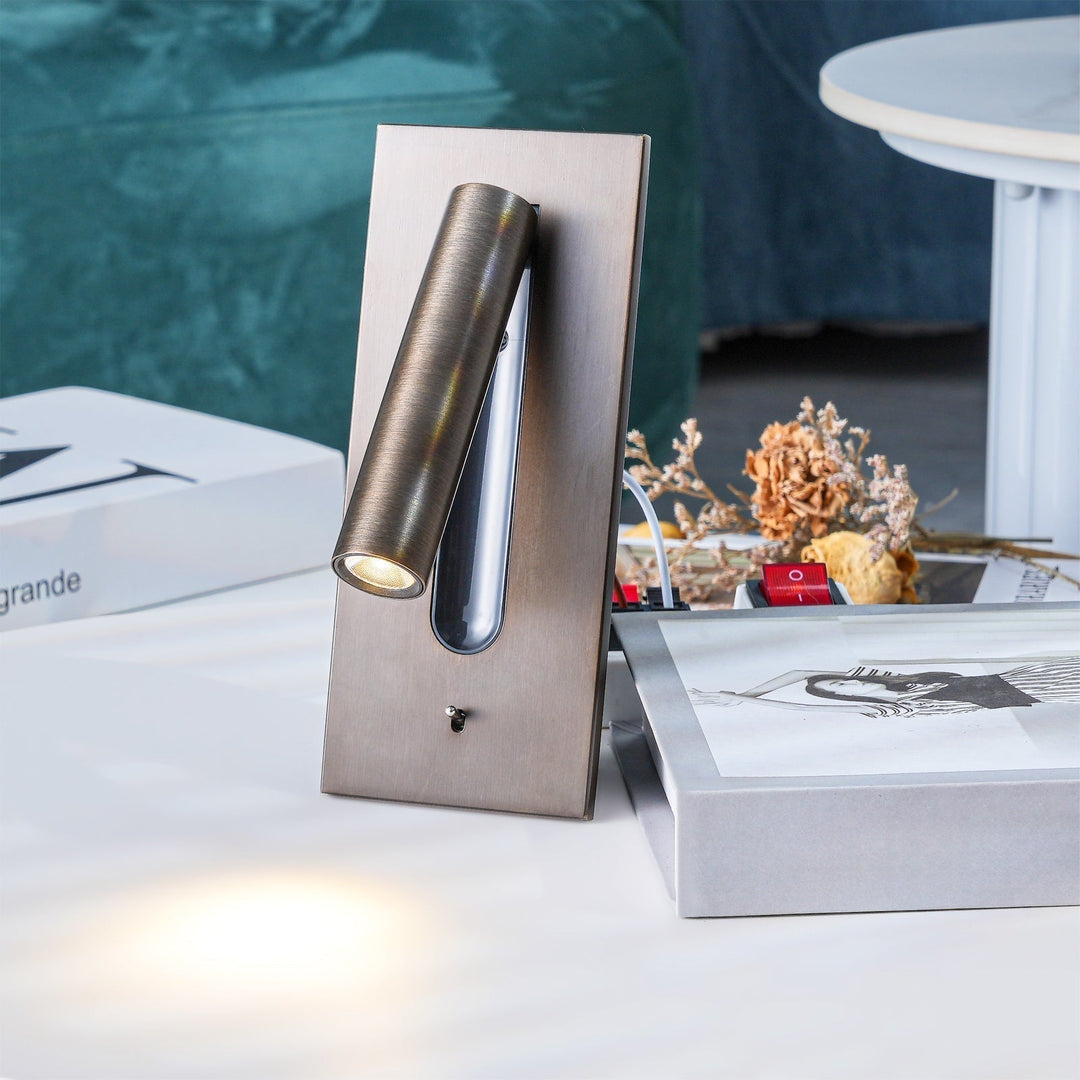 Bronzefarbene Wandleuchte leuchtend auf einem Tisch, umgeben von Büchern und Trockenblumen 28