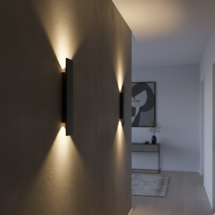 Schwarze Wandleuchten in einem Flur im Innenraum, das warme Licht beleuchtet die strukturierte Wand nach oben und unten. 3
