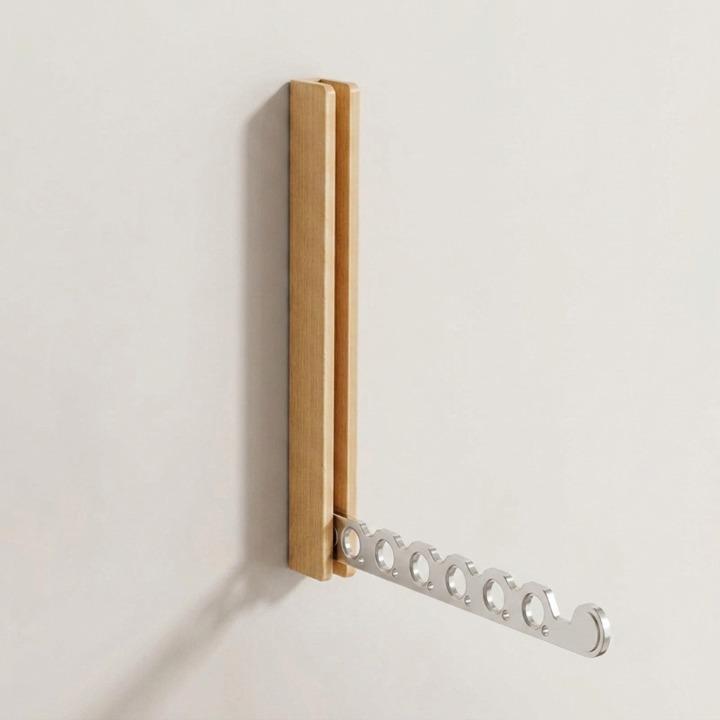Helle Holzhalterung an der Wand mit schräg ausgeklapptem silbernem Metallarm mit sechs runden Aussparungen, ohne Kleidung. 9