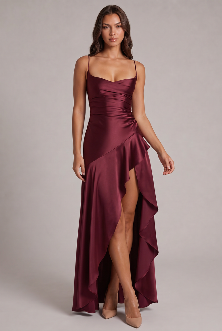Weinrotes Satin-Maxikleid mit Spaghettiträgern, Wickeloptik und Volant-Schlitz, frontal getragen von einem Model mit nudefarbenen Pumps. 1
