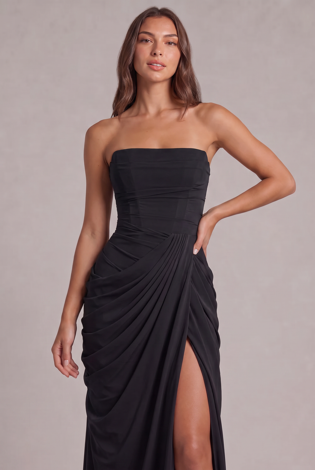 Nahaufnahme des schwarzen Kleides: Model in Halbfigur mit Corsagenoberteil, plissierter Draperie und Beinschlitz 26