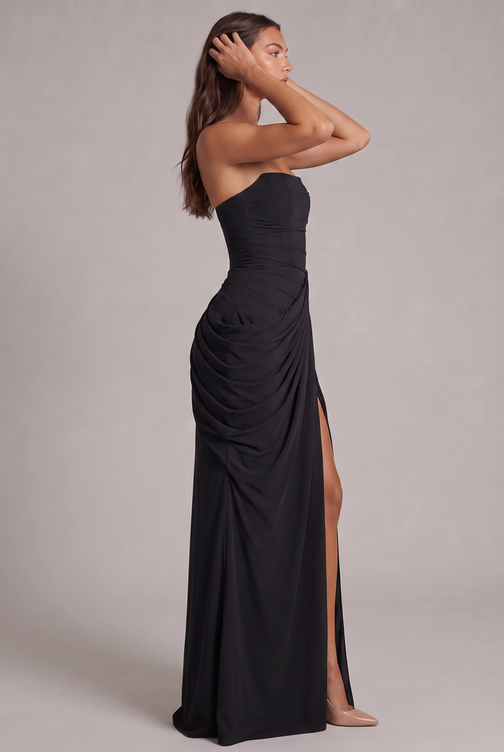Schwarzes Kleid im Profil: Model mit den Händen im Haar zeigt Corsagenschnitt, Raffung und seitlichen Schlitz 27