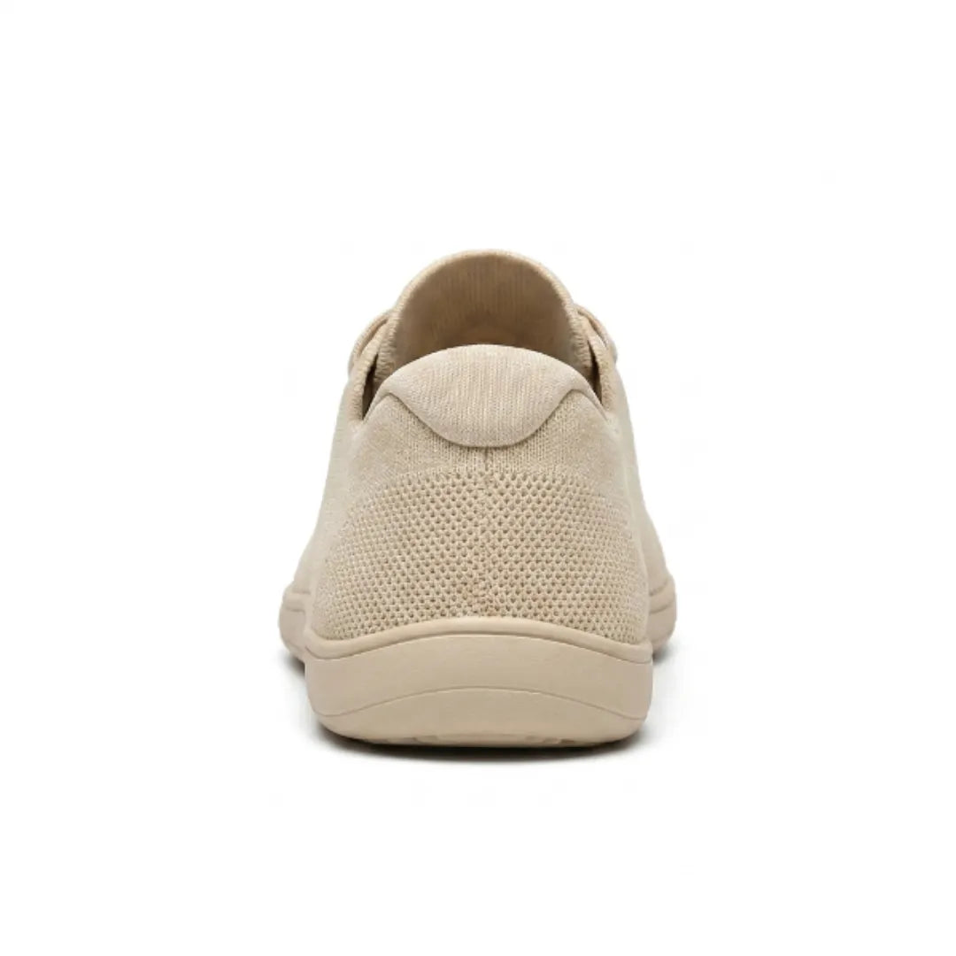 Beiger Sneaker von hinten, zeigt die gepolsterte Fersenkappe, das gelochte Mesh und die flache Sohle. 9