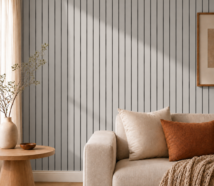 Graue Lamellenwand im Streiflicht neben Sofa mit Kissen, Beistelltisch und Vase 16