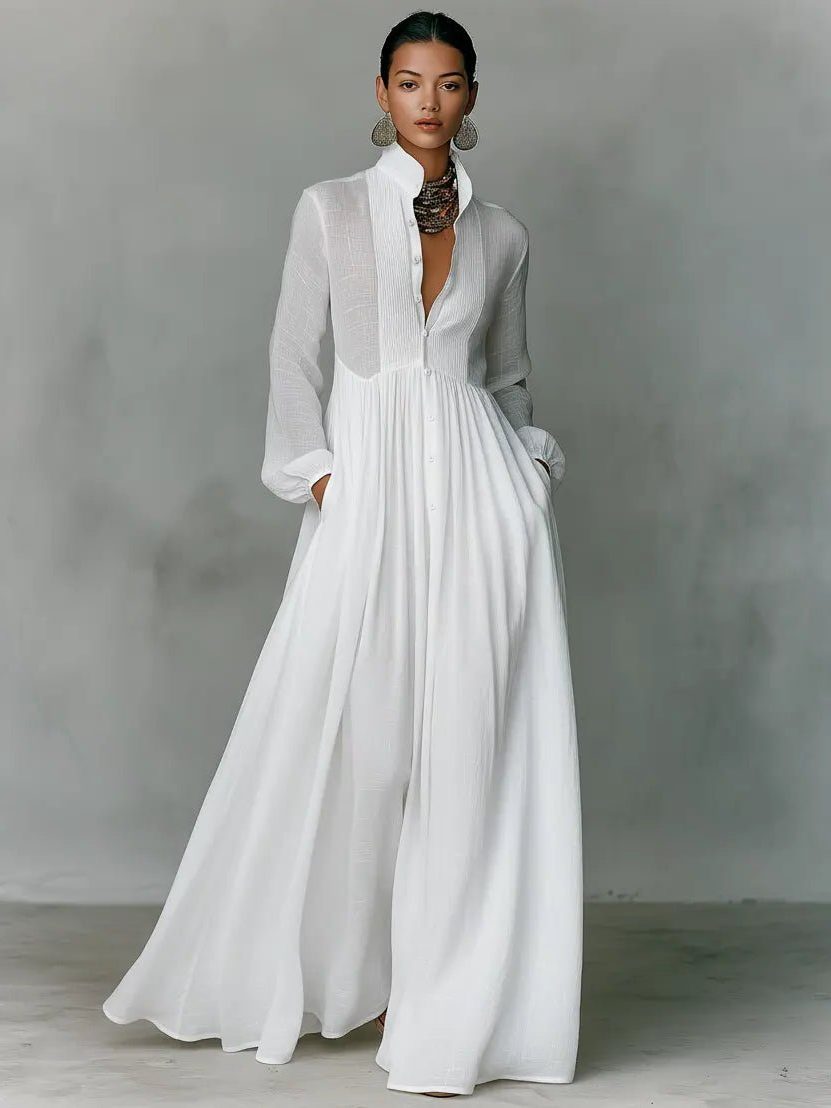 Weißes Maxikleid in ganzer Frontansicht, Model mit Ohrringen und Kette, Hände in den Taschen 7