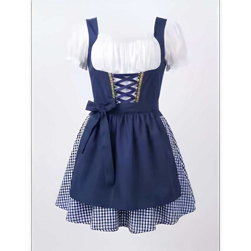 Dunkelblaues Dirndl mit weißer Puffärmel-Bluse, Schnürung am Mieder, Schürze mit Schleife und blau-weiß kariertem Rock vor hellem Hintergrund. 2