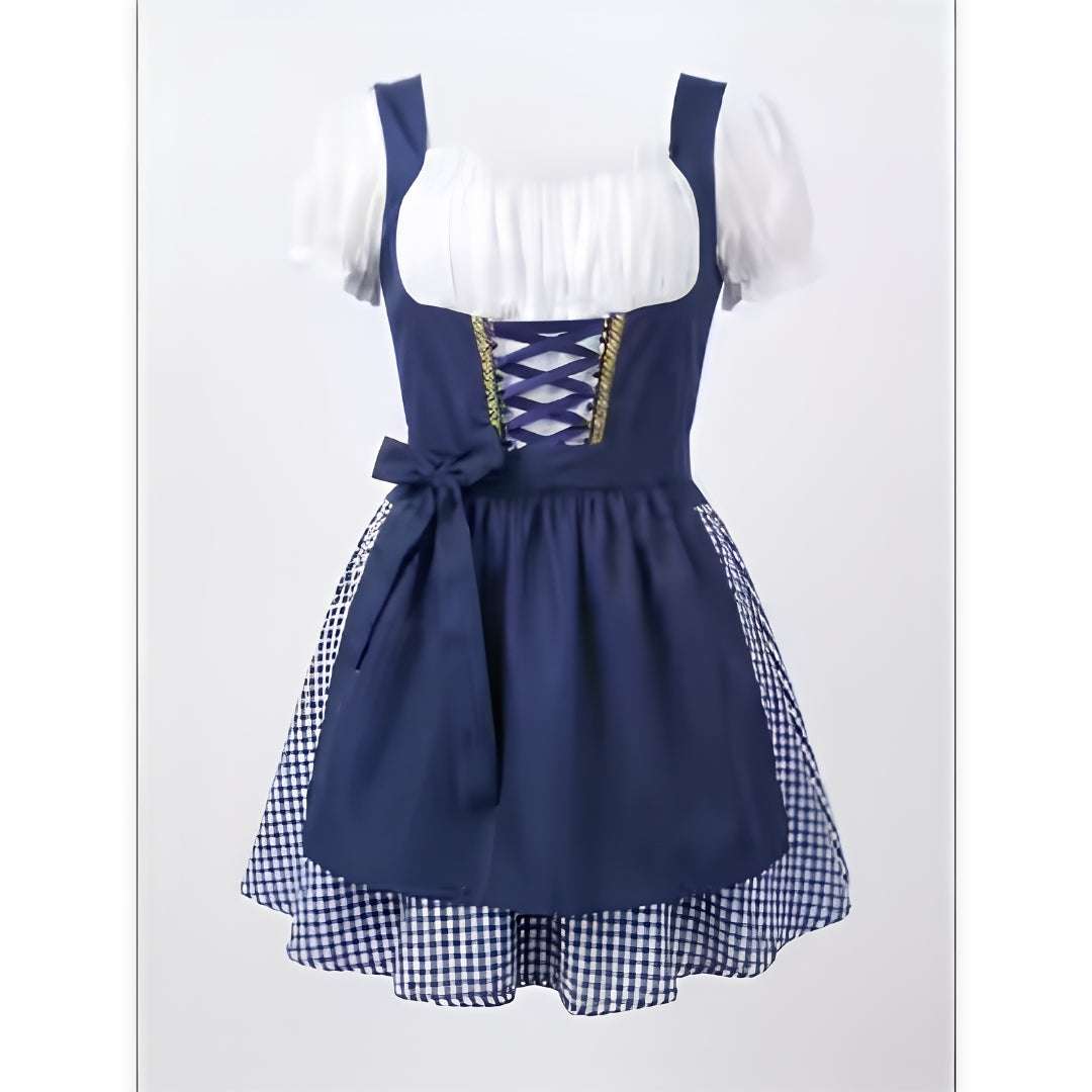 Dunkelblaues Dirndl mit weißer Puffärmel-Bluse, Schnürung am Mieder, Schürze mit Schleife und blau-weiß kariertem Rock vor hellem Hintergrund. 2