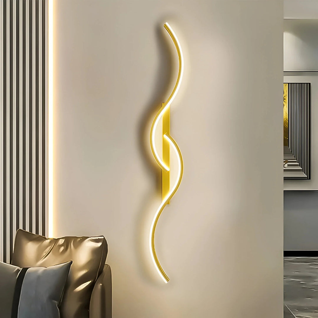 Goldfarbene, leuchtende Wellenleuchte an heller Wand neben einem Ledersofa im Wohnzimmer 1