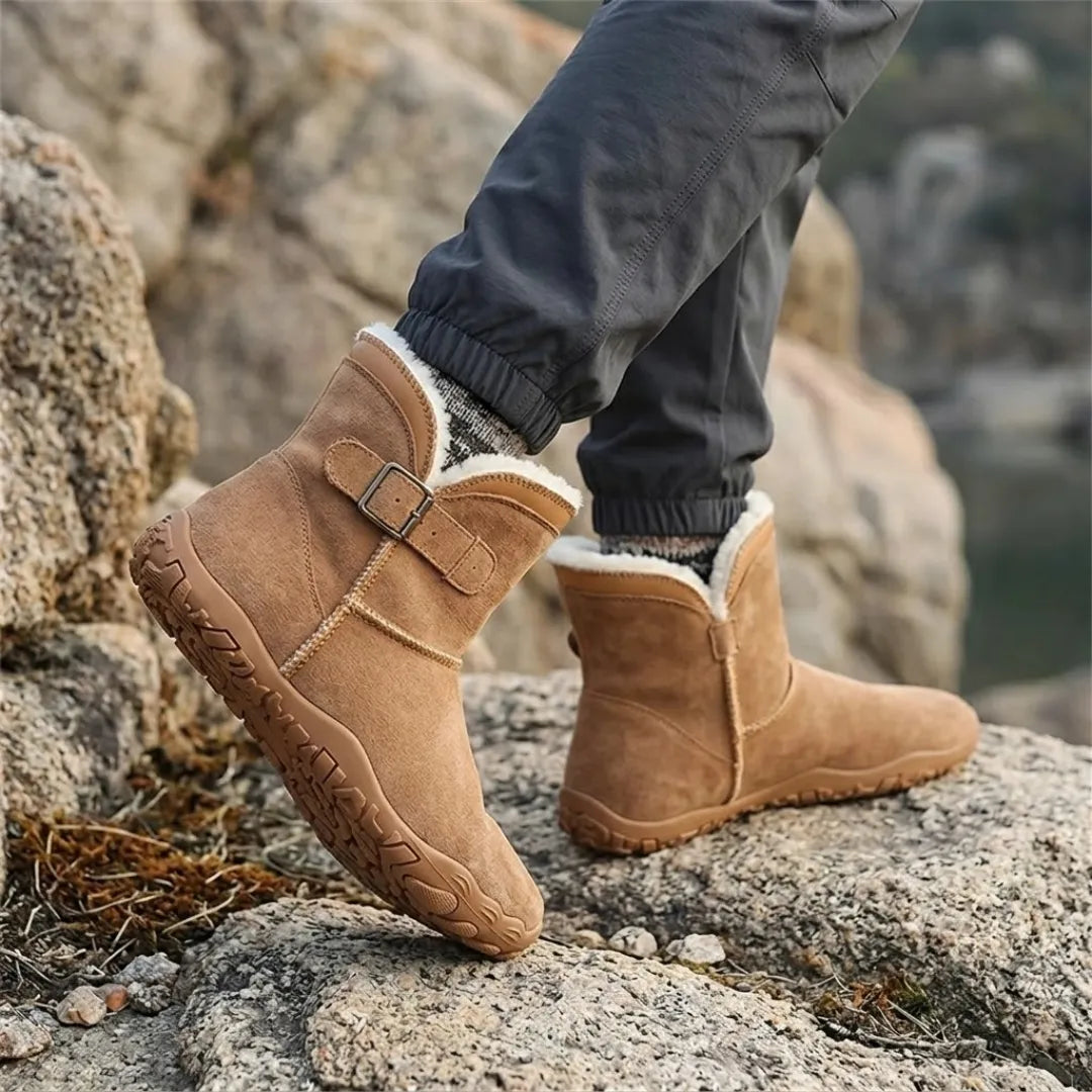 Hellbraune Stiefel mit hellem Fellfutter, getragen auf Felsen, dazu dunkle Hose und gemusterte Socken 20