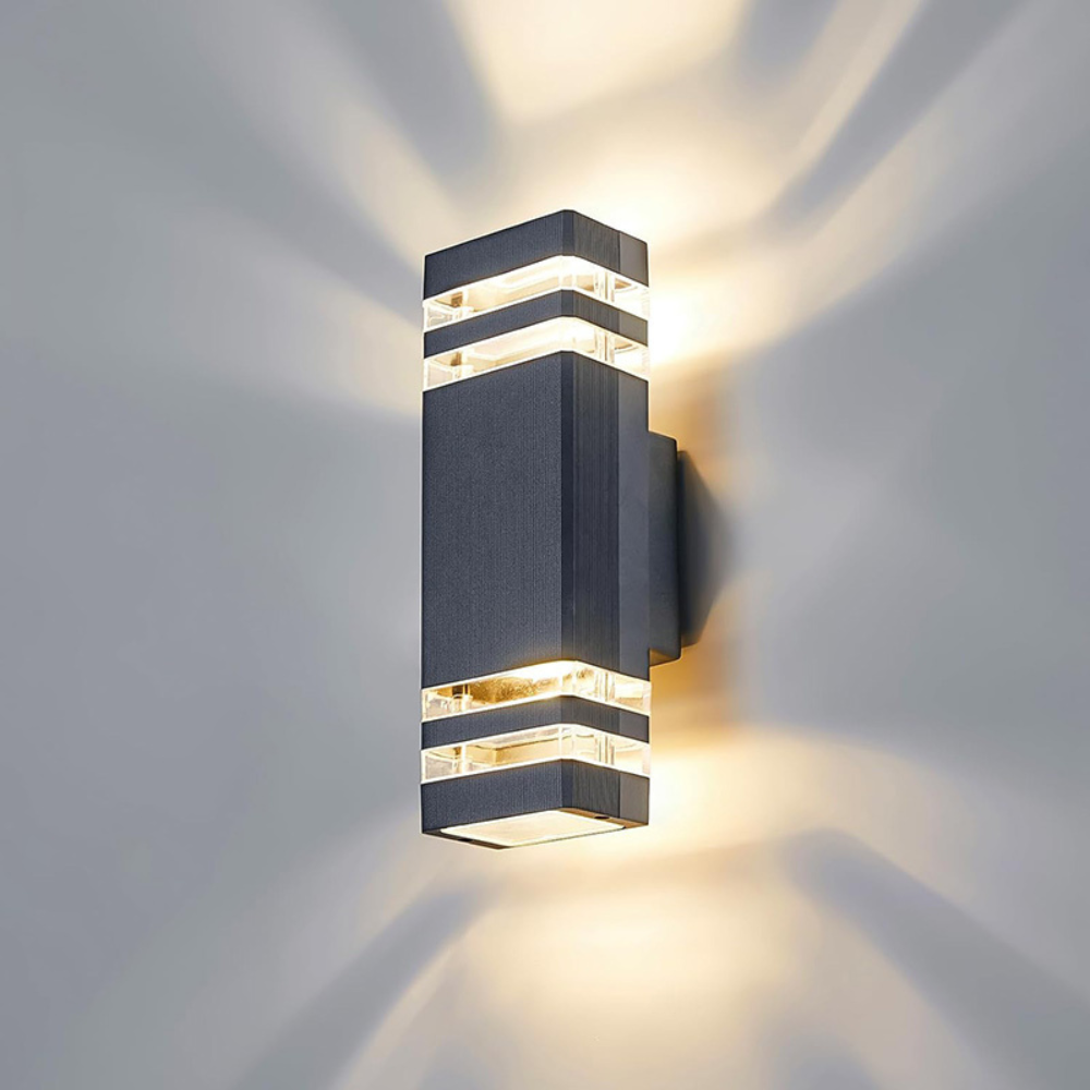 Anthrazitfarbene eckige Wandleuchte mit zwei Lichtringen je Seite, die warmes Licht in Streifen an die Wand wirft 6