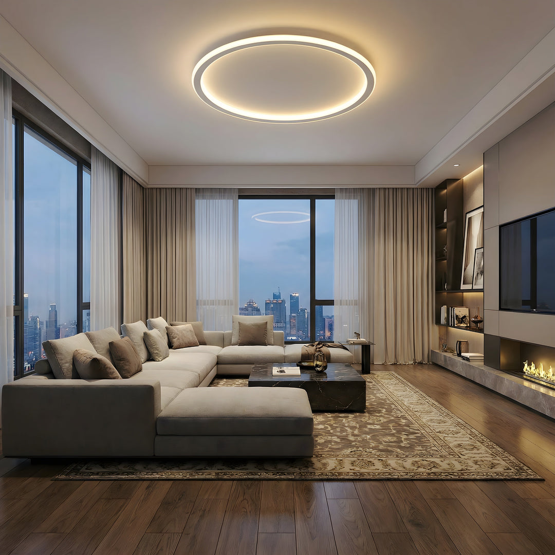 Große Ringleuchte über einem geräumigen Wohnzimmer mit Ecksofa, Kamin, Fernseher und Blick auf die Stadt am Abend. 7