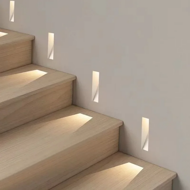 Schmale Einbauleuchten in der Wand neben einer Holztreppe beleuchten die einzelnen Stufen 6