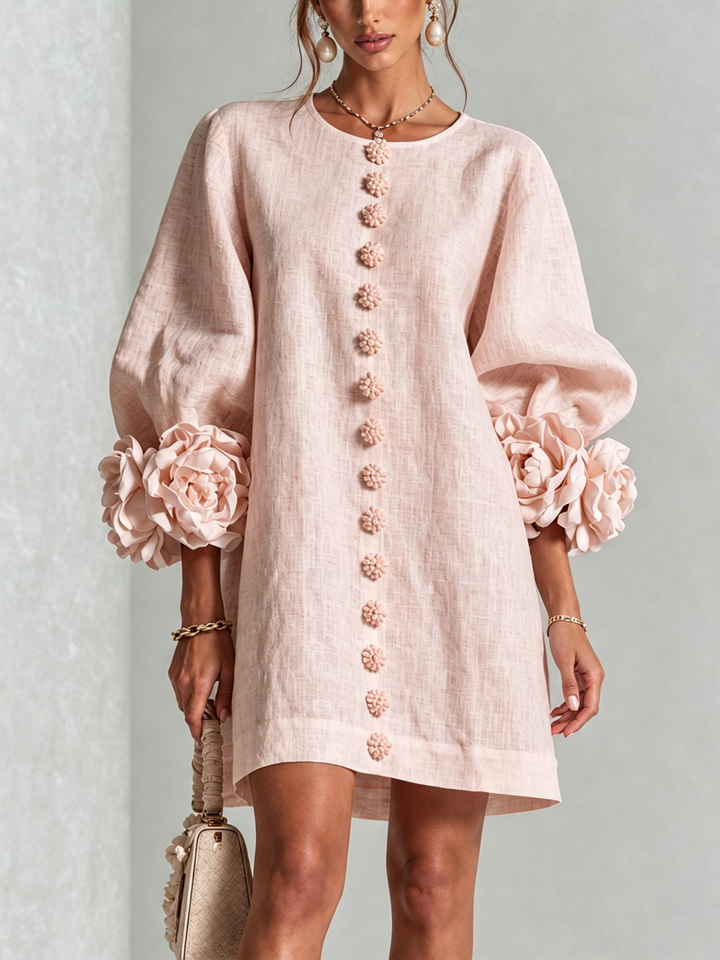 Frontansicht des Kleids in zartem Rosa mit Blütenknöpfen und Blütenverzierung an den Ärmelenden 5