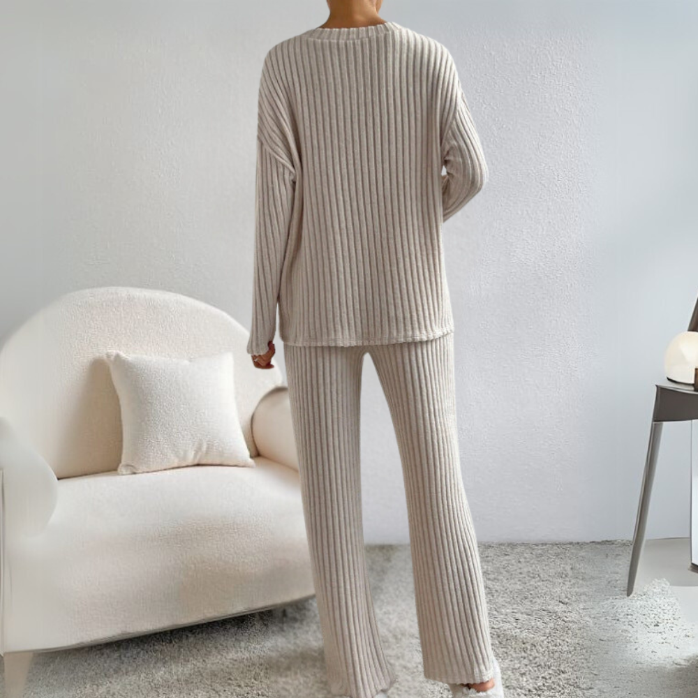 Frau in beigem Strick-Loungewear-Set, gemütliches Wohnzimmer, modernes Interieur.