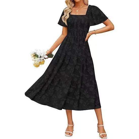 Schwarzes Kleid mit kurzen Flatterärmeln und gestuftem Rock, getragen mit Blumenstrauß vor weißem Hintergrund 5