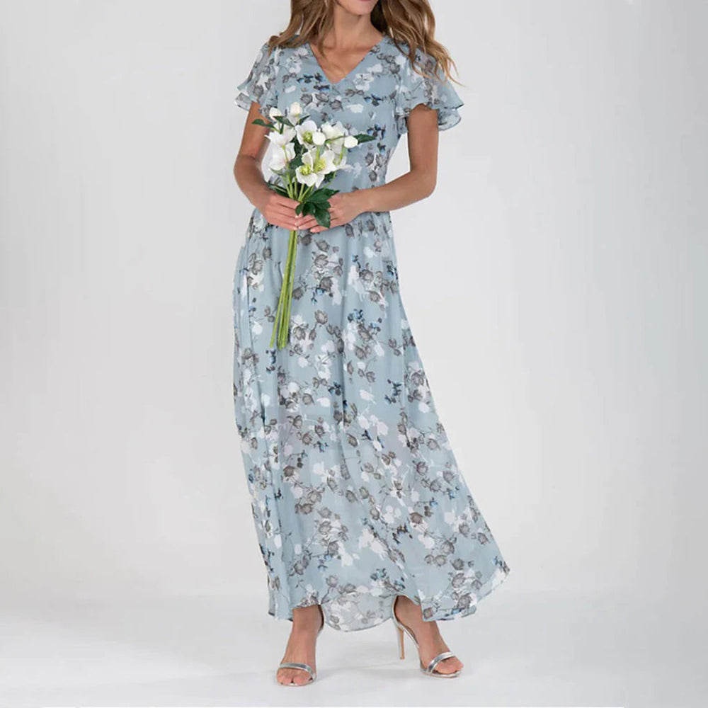 Frau in blauer, geblümter Maxikleid, hält weiße Blumen, elegante Mode, Sommerkleid.