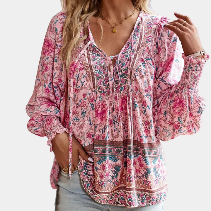 Frau in rosa geblümter Bluse, Boho-Stil, lange Ärmel, V-Ausschnitt, lässige Damenmode.
