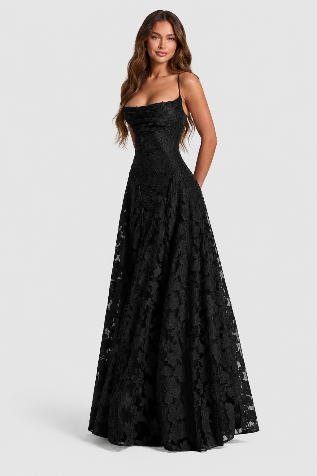 Schwarzes Spitzenkleid mit drapiertem Ausschnitt und schmalen Trägern, frontal am lächelnden Model, Hände hinter dem Rücken. 10
