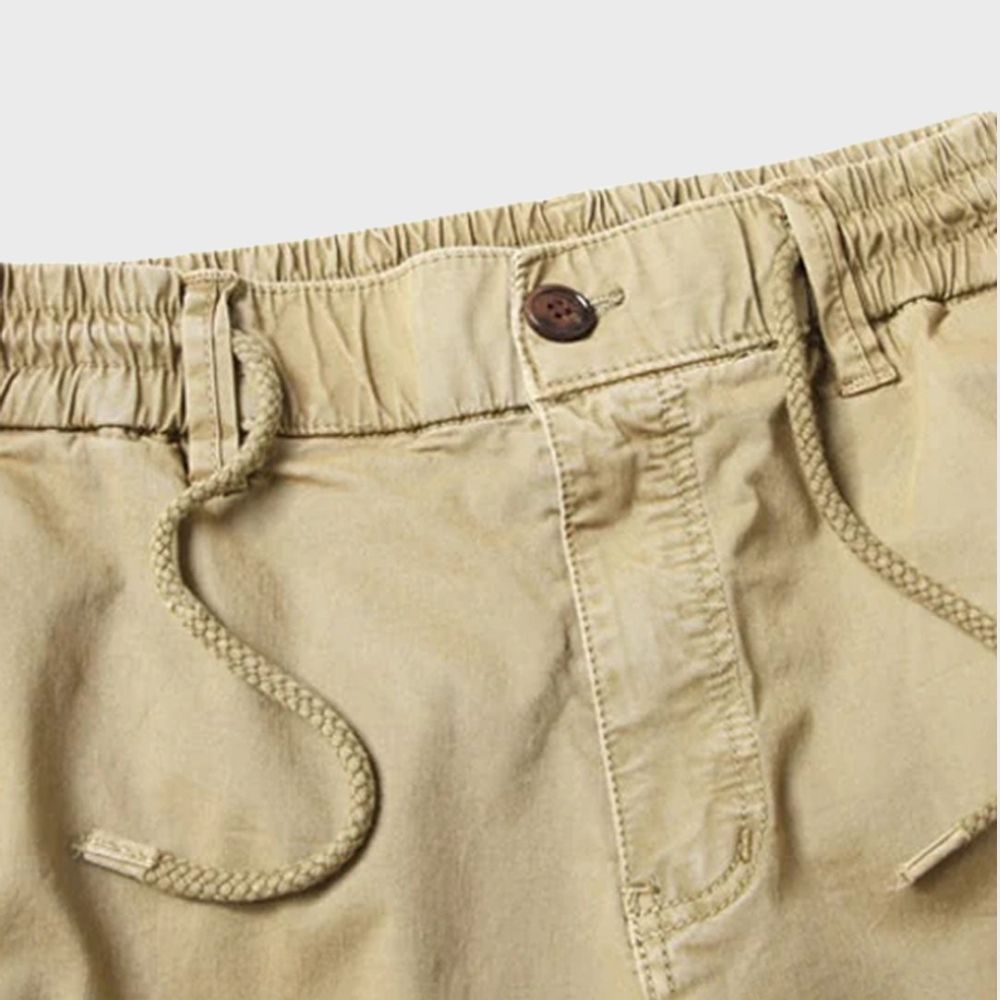 Beige Cargohose für Herren mit Kordelzug, elastischem Bund und Knopfverschluss.