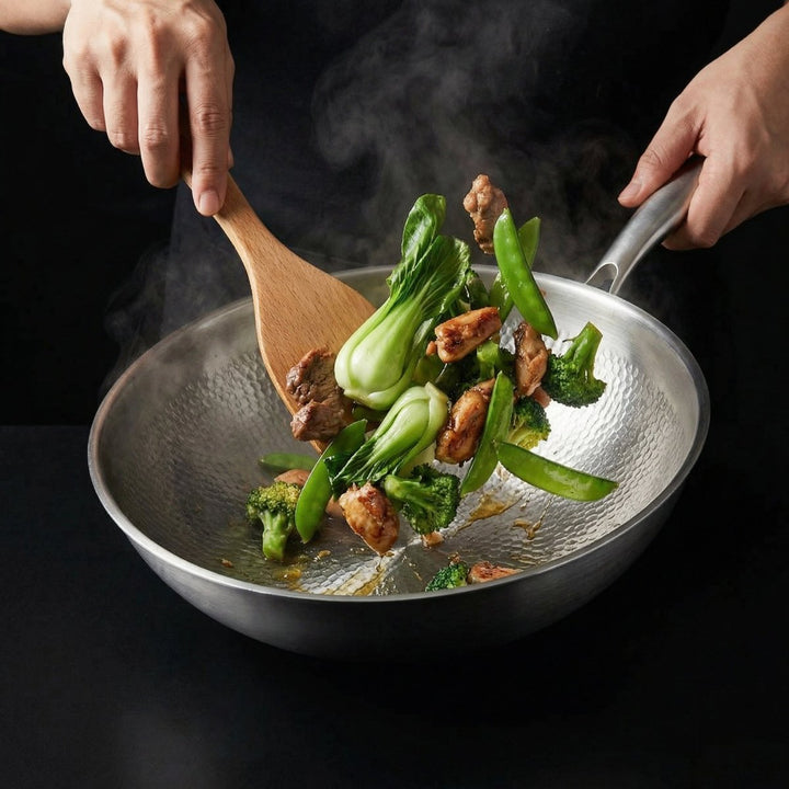 Zwei Hände rühren mit einem Holzspatel Pak Choi, Brokkoli, Zuckerschoten und Fleisch im dampfenden Wok. 8