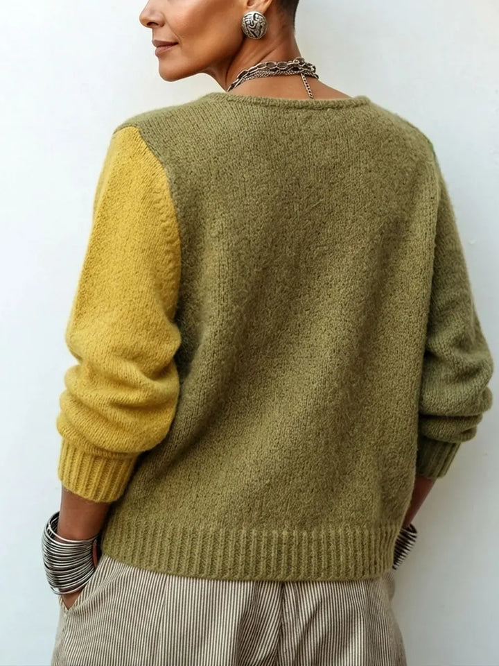 Rückansicht des Strickpullovers: Rücken und ein Ärmel in Olive, der andere Ärmel in Senf, gerippter Saum und Bündchen. 3