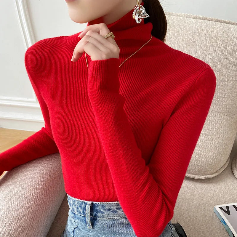 Leuchtend roter Rollkragenpullover, seitlich fotografiert, Model stützt die Hand ans Kinn, dazu Jeans 5