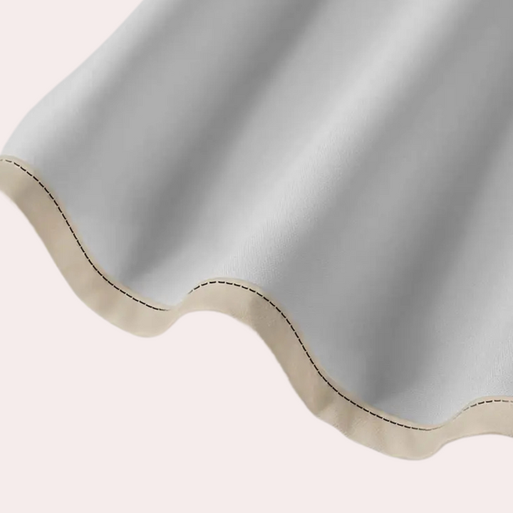 Graues, wellenförmiges Leder mit beiger Naht, Nahaufnahme, hochwertiges Material.